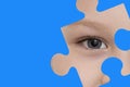 Kid spies through a blue puzzle. Symbol of autism awareness Royalty Free Stock Photo