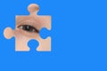 Kid spies through a blue puzzle. Symbol of autism awareness Royalty Free Stock Photo