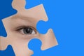 Kid spies through a blue puzzle. Symbol of autism awareness