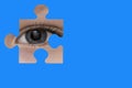 Kid spies through a blue puzzle. Symbol of autism awareness Royalty Free Stock Photo