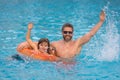 Kid splash water in pool. Father and son swimming and splashing in blue sea water. Family on summer holiday. Happy Royalty Free Stock Photo