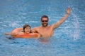 Kid splash water in pool. Father and son swimming and splashing in blue sea water. Family on summer holiday. Happy Royalty Free Stock Photo