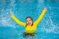 Kid splashing in summer water pool. Kid splash in swim pool. Excited happy little boy jumping in pool, water fun. Kid Royalty Free Stock Photo