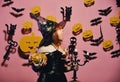 Kid in spooky witches costume holds carved pumpkin and chandelier Royalty Free Stock Photo