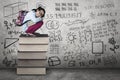 Kid squat on books with scribble at wall Royalty Free Stock Photo