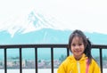 Kid standing in front of Kawaguchiko lake and mount fuji in winter