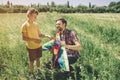 Kid is standing while his dad is sitting in squatt position. THey are holding kite. Guys want to play together and to Royalty Free Stock Photo