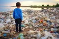 Kid standing near landfill next to mountain of plastic wastes looking far into hopelessness Royalty Free Stock Photo