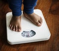 Kid standing on weight scale Royalty Free Stock Photo