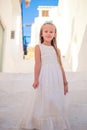 Kid at street of typical greek traditional village with white walls and colorful doors on Mykonos Island Royalty Free Stock Photo