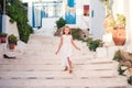 Kid at street of typical greek traditional village with white walls and colorful doors on Mykonos Island Royalty Free Stock Photo