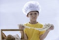 Kid stretch raw sticky dough with baking homemade bread.