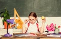 Kid student in school. Schoolgirl sit desk chalkboard background. Girl small child eating apple snack. School break Royalty Free Stock Photo