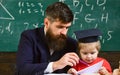 Kid studies individually with teacher, at home. Father with beard, teacher teaches son, little boy. Individual schooling