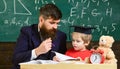 Kid studies individually with teacher, at home. Father with beard, teacher teaches son, little boy. Teacher and pupil in