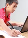 Kid studying with books and laptop Royalty Free Stock Photo