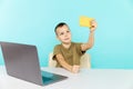 Kid studying online at home on the laptop in the blue room. Royalty Free Stock Photo