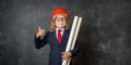 Kid in suit with construction tools. Little girl in businessman suit and glasses. little girl in red safety helmet Royalty Free Stock Photo