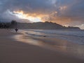 Kid surfer holding bodyboard leaving ocean at sunset Royalty Free Stock Photo