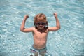 Kid in swimming pool. Excited cute little boy in sunglasses in pool in sunny day. Royalty Free Stock Photo