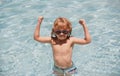 Kid in swimming pool. Excited cute little boy in sunglasses in pool in sunny day. Royalty Free Stock Photo