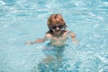 Kid in swimming pool. Funny cute little boy in sunglasses in pool in sunny day. Royalty Free Stock Photo