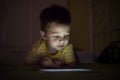Kid with tablet in the dark