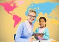 Kid and teacher holding tablet in front of colorful world map Royalty Free Stock Photo