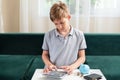 Kid teen boy counting money and taking notes, saving money in a piggy bank. Learning financial responsibility and Royalty Free Stock Photo