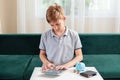 Kid teen boy counting money and taking notes, saving money in a piggy bank. Learning financial responsibility and Royalty Free Stock Photo