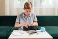 Kid teen boy counting money and taking notes, saving money in a piggy bank. Learning financial responsibility and Royalty Free Stock Photo