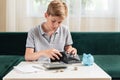 Kid teen boy counting money and taking notes, saving money in a piggy bank. Learning financial responsibility and Royalty Free Stock Photo