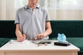 Kid teen boy counting money and taking notes, saving money in a piggy bank. Learning financial responsibility and Royalty Free Stock Photo