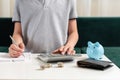 Kid teen boy counting money and taking notes, saving money in a piggy bank. Learning financial responsibility and Royalty Free Stock Photo