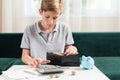 Kid teen boy counting money and taking notes, saving money in a piggy bank. Learning financial responsibility and Royalty Free Stock Photo