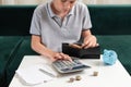 Kid teen boy counting money and taking notes, saving money in a piggy bank. Learning financial responsibility and Royalty Free Stock Photo