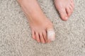 Kid teenager bare foot with a bandage on a toe, wounded toe or ingrown nail first aid Royalty Free Stock Photo