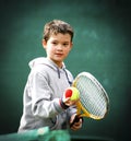 First tennis lessons for the smiling kid with the two colours ball for beginners is ready for a service Royalty Free Stock Photo