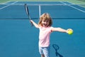 Kid tennis player on tennis court. Boy hitting forehand in tennis. Royalty Free Stock Photo