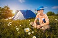 Kid with a tent on a camomile meadow