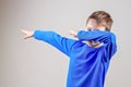 Kid throws dab on the background of a gray wall