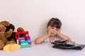 Kid tired because of too much information. Stressed little girl sitting near phones, smartphones, laptops, pc tablets. Royalty Free Stock Photo