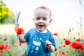 Happy toddler smiling in a field of poppies Royalty Free Stock Photo