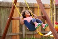 Kid toddler girl swinging on a playground swing Royalty Free Stock Photo