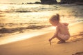 Kid toddler girl writing on sand beach surf during summer holidays concept happy childhood travel lifestyle Royalty Free Stock Photo
