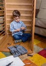 Kid with tools assembling a new furniture