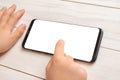 Kid touch smart phone screen on white wooden desk. Isolated screen for mockup, app or game design presentation Royalty Free Stock Photo