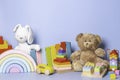 Kid toys collection isolated on blue background. Teddy bear, white bunny, wooden, plastic and fluffy educational baby Royalty Free Stock Photo