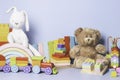 Kid toys collection isolated on blue background. Teddy bear, white bunny, wooden, plastic and fluffy educational baby Royalty Free Stock Photo