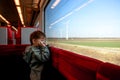 Kid in traine look in window on wind farm. Renewable energies and sustainable resources - wind mills. High speed express